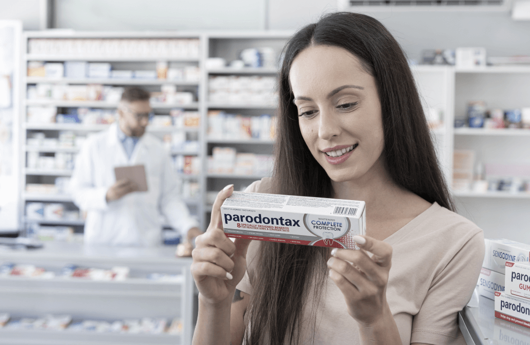 Woman in a pharmacy looking at Parodontax toothpaste