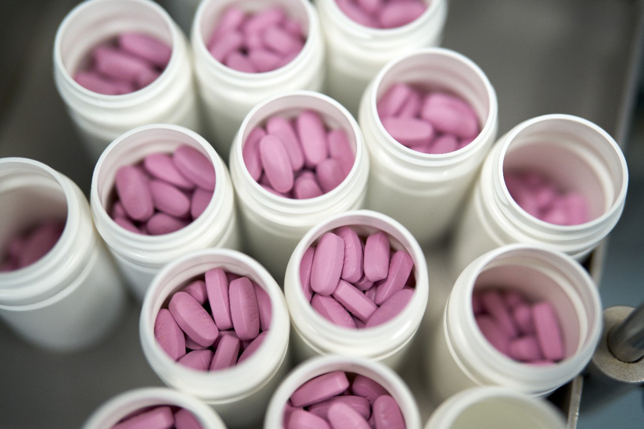 Top view of various Centrum vitamin containers with visible pills inside