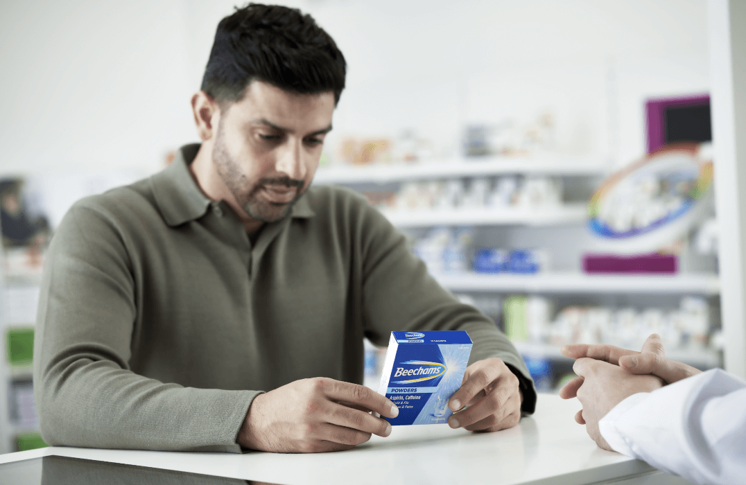 Male customer in shop looking at packet on counter top