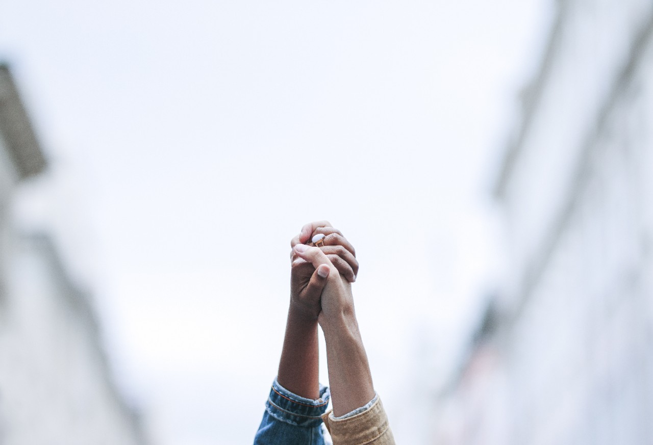 Two people holding hands in the air