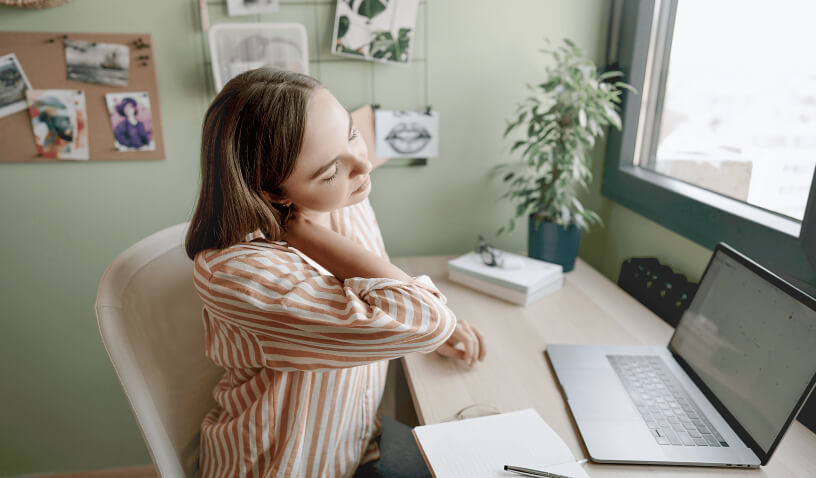 Woman sitting down with pain in neck