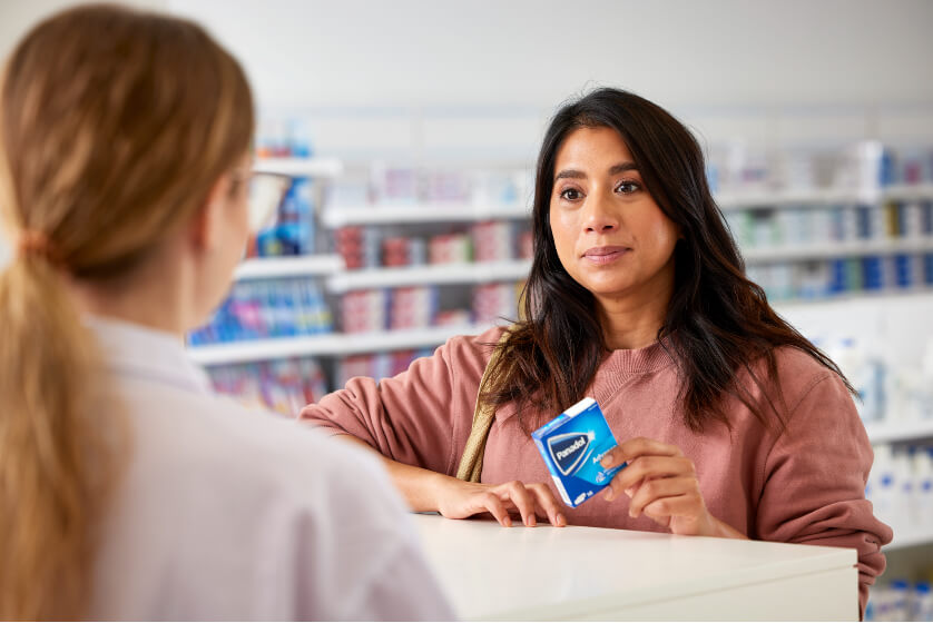 Woman holding Panadol over counter