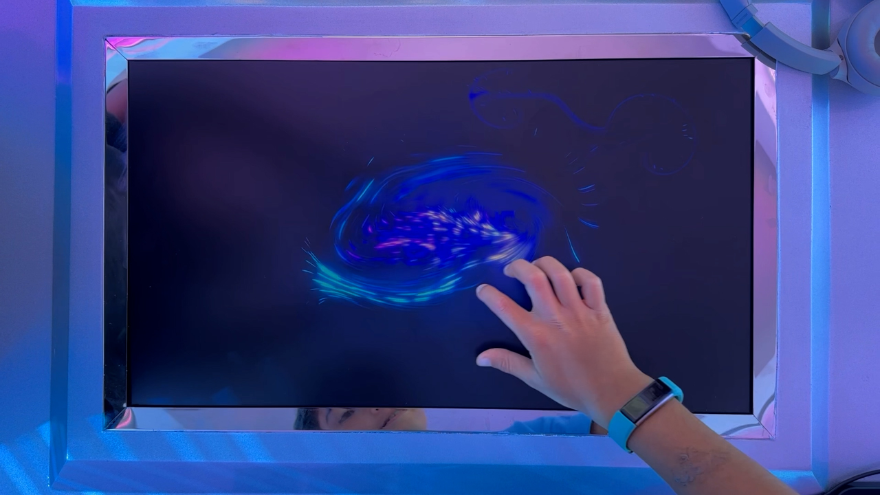 A hand hovering over a screen with AI features at the Sensodyne Café in Dubai