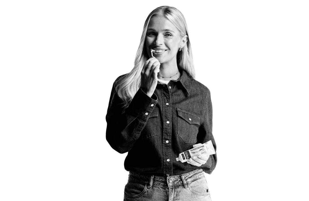 Blonde woman holding a toothbrush and toothpaste