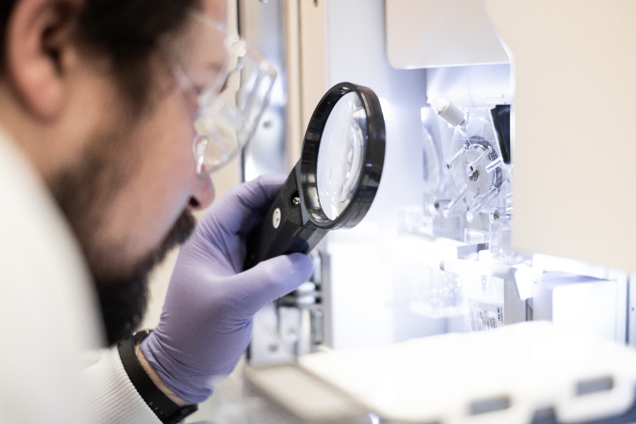 Scientist examining through magnifying glass