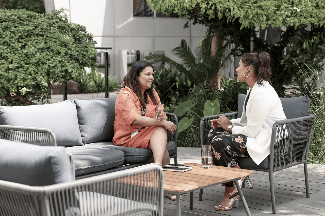 Two women sitting down outside