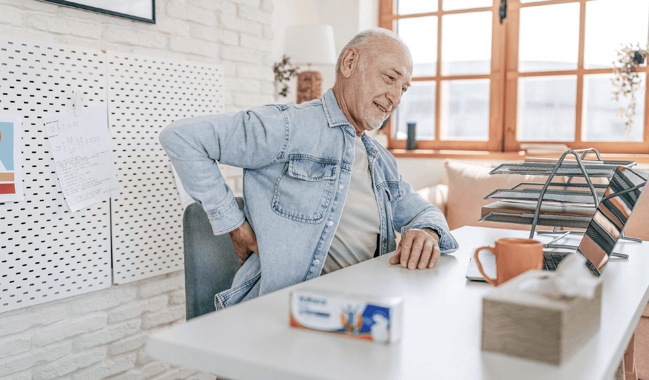 Old man sitting down with pain in back
