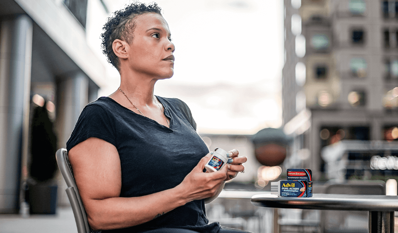 Woman sitting down holding Advil
